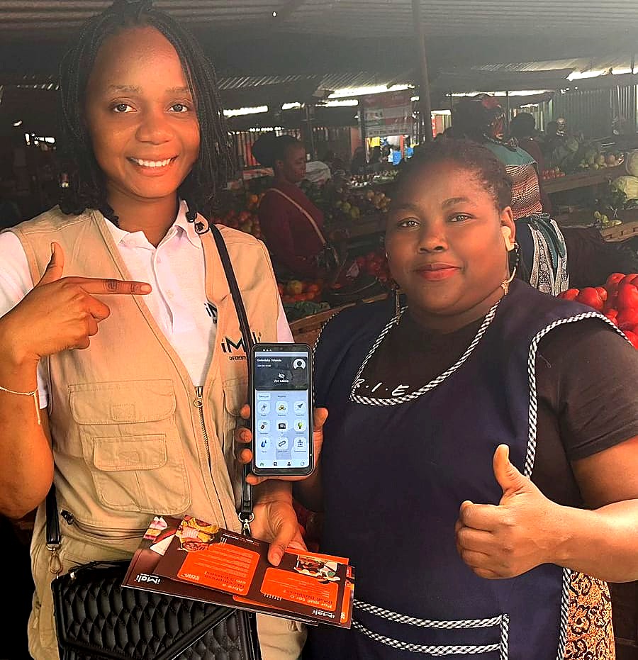 Agente Mama Soko e comerciante no mercado, com o terminal de pagamento iMali Business